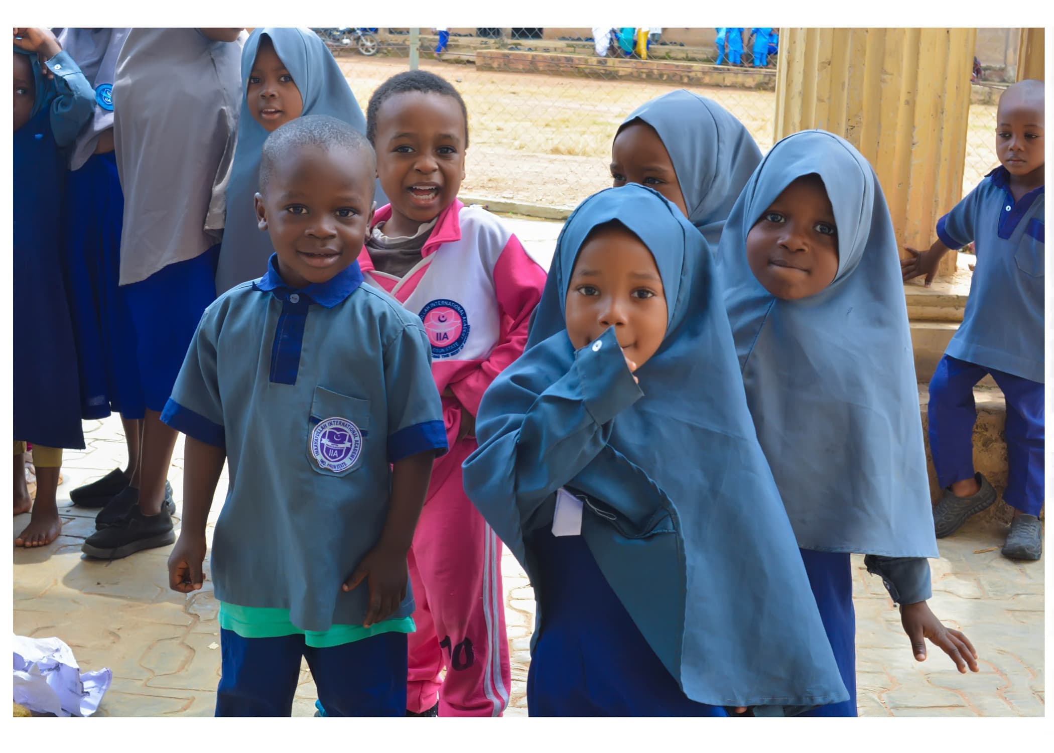 A group of young Inaayatullah pupils smiling together on campus