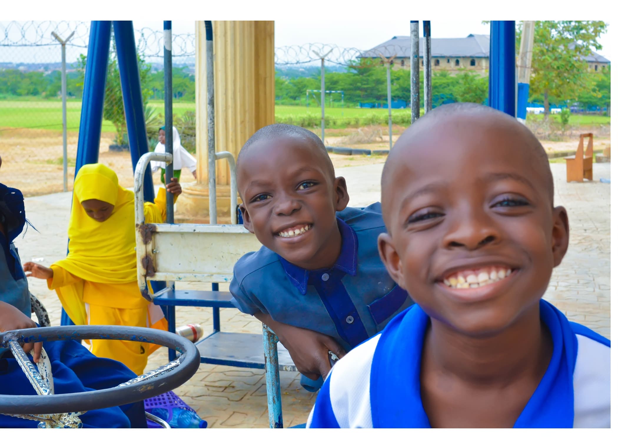 Two smiling Inaayatullah pupils enjoying time on the school playground
