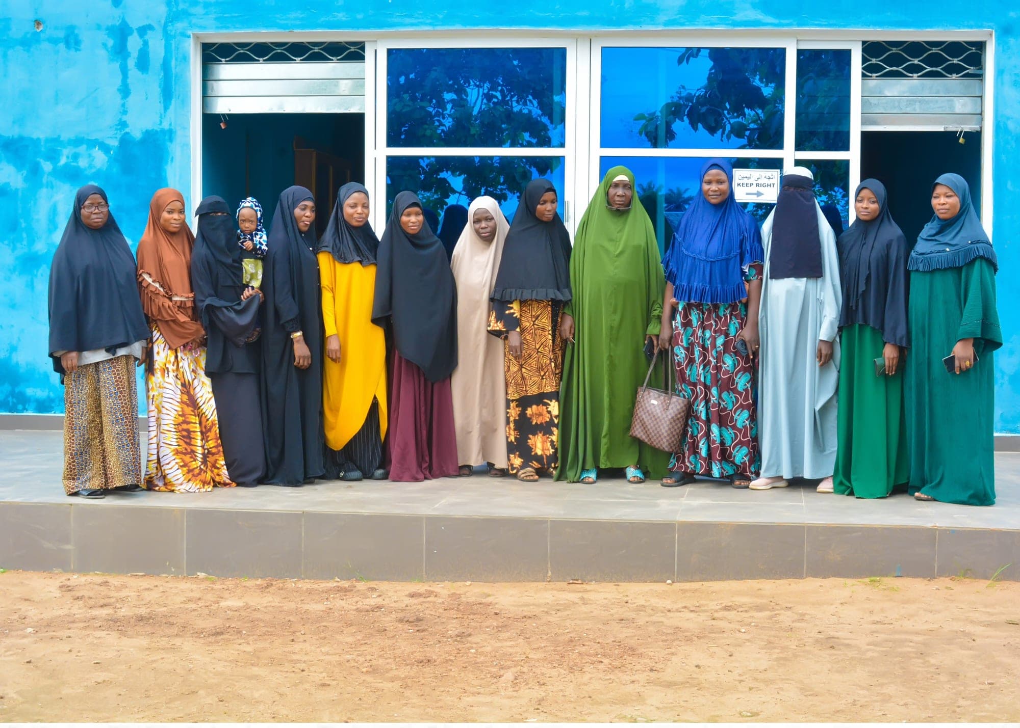 Female members of staff standing together in front of the Academy building