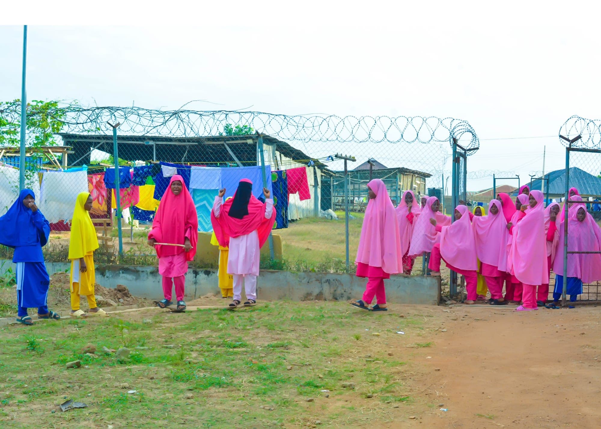 Girls in pink uniforms lined up together on the school grounds