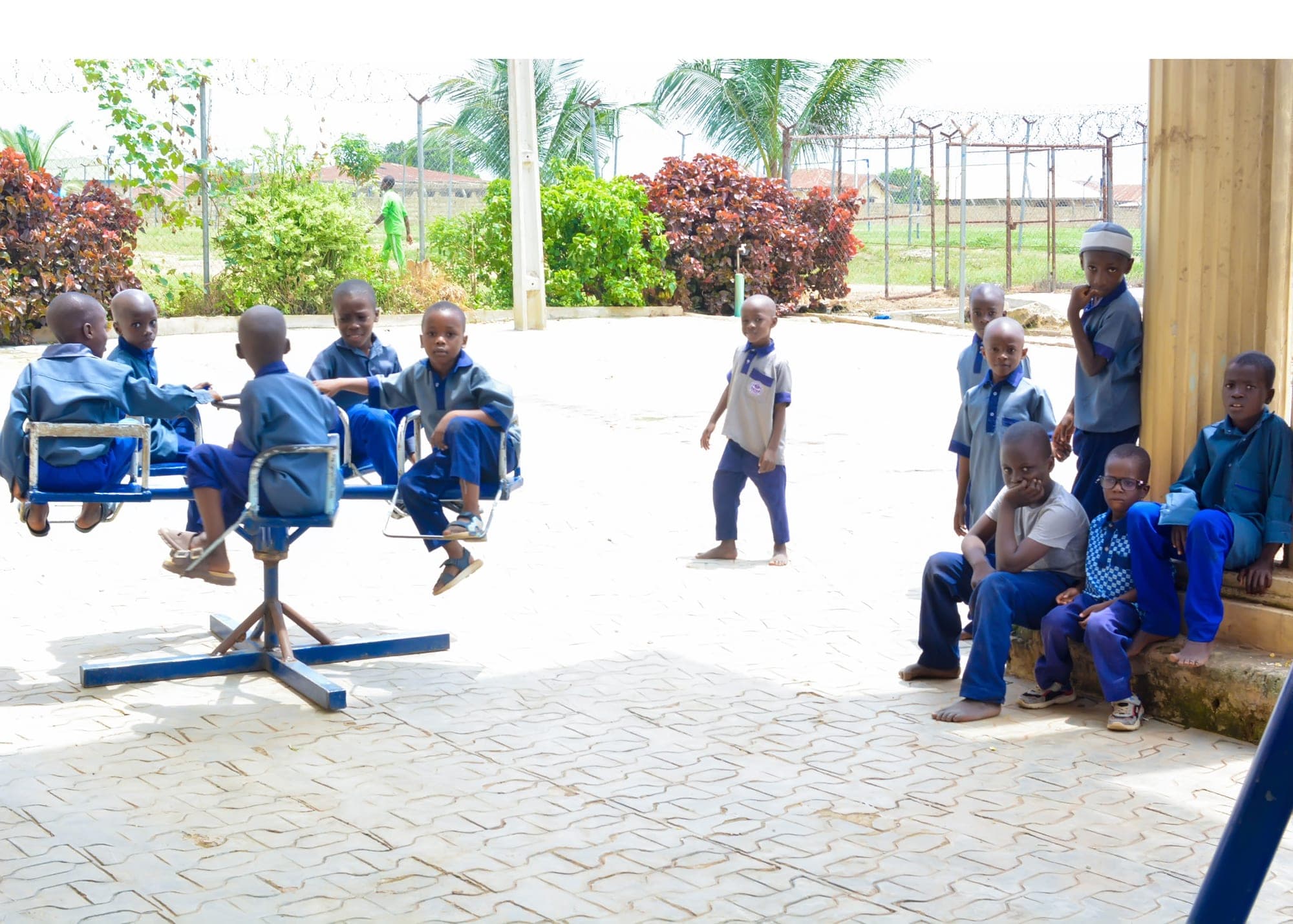Pupils playing and sitting together in the school courtyard at break time